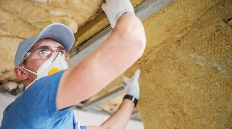 man fixing ceiling insulation